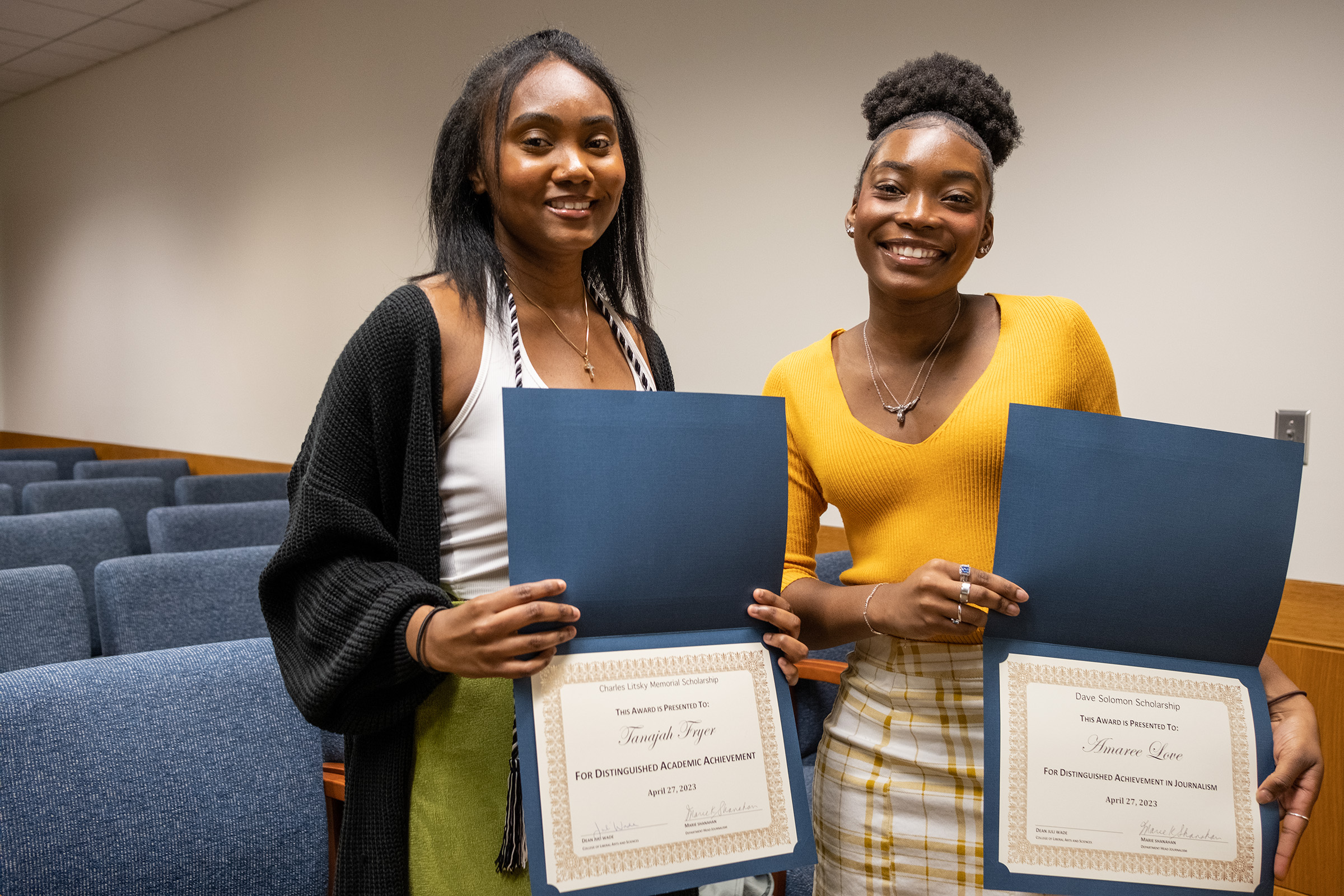 Two UConn Journalism majors hold up scholarship certificates after the 2023 awards ceremony.